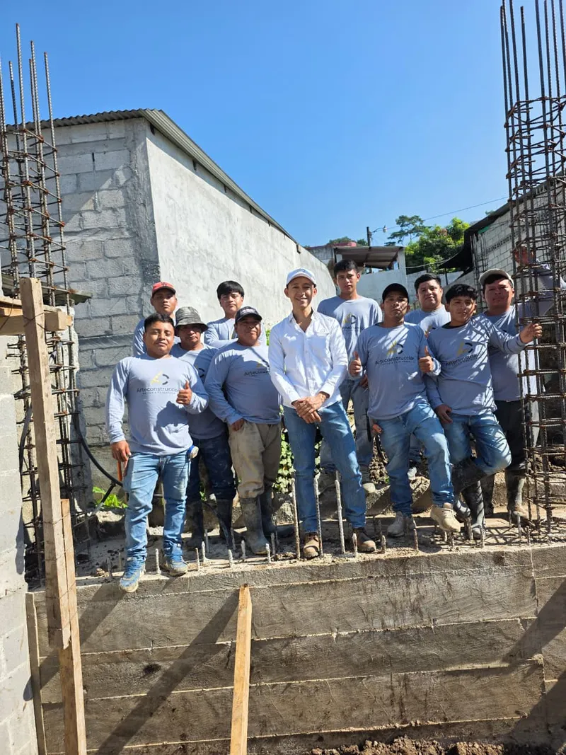 Equipo de Arteconstrucción reunido en obra junto a la cimentación y columnas de refuerzo de un proyecto en construcción